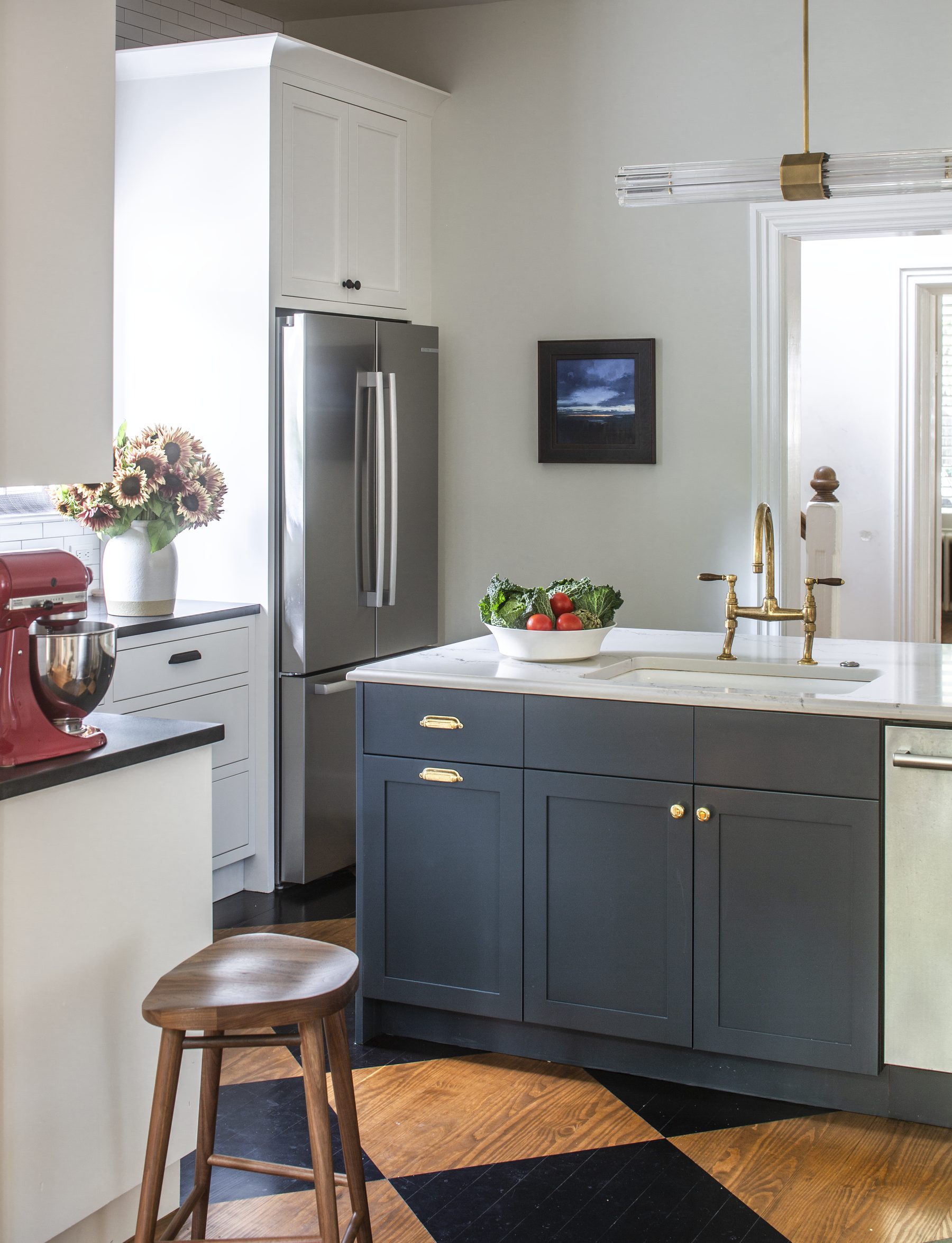Kitchen with a blue-gray island, checkerboard floor, and brass hardware — Cleveland Park Residence by Christopher Patrick Interiors